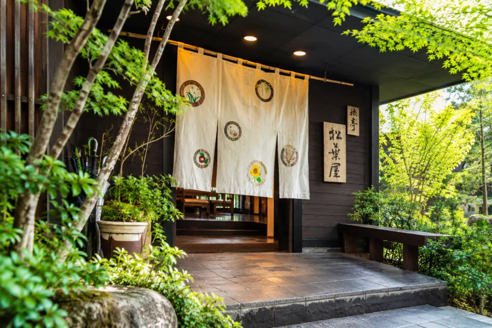 旅亭 松葉屋の暖簾と花の意匠がある正面入口