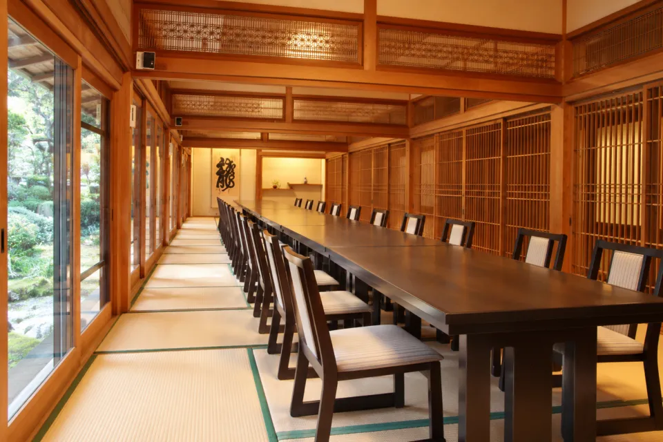 川魚料理 龍水亭の長いテーブルと椅子を配した宴会場