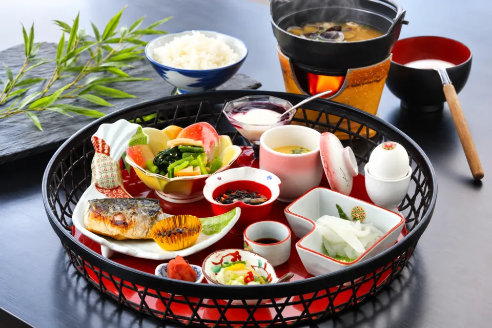 雨情の宿 新つたのご飯と汁物、小鉢を並べた朝食の一例