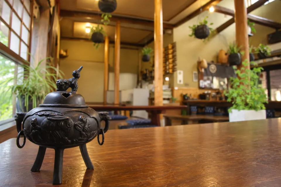 鮎料理の丹一の卓上の金属製香炉と店内のしつらえ