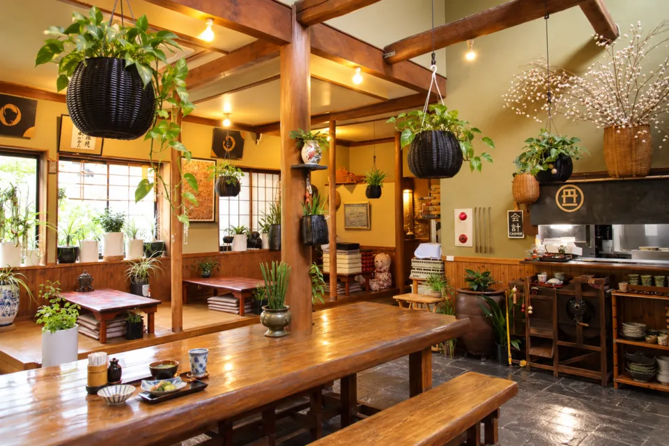 鮎料理の丹一の木の梁と植物のある店内