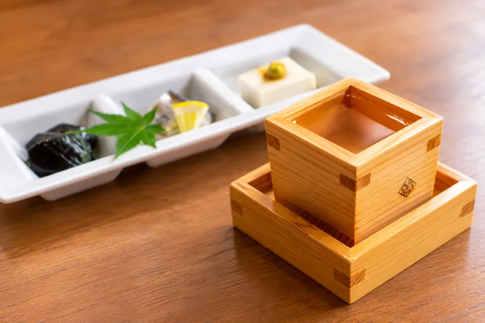 冨來屋本舗 本館の枡に注がれたお酒と小鉢料理