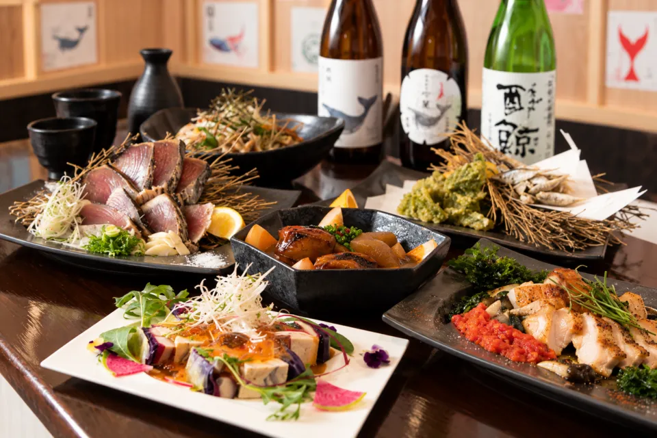 とさごはん 酔鯨亭の酒瓶と料理を並べたコースの食卓