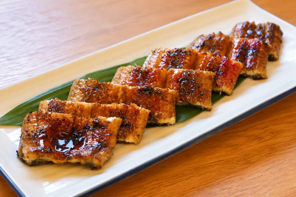 うなぎ料理 鹿六 新宮店の白い長皿に盛ったうなぎの蒲焼き