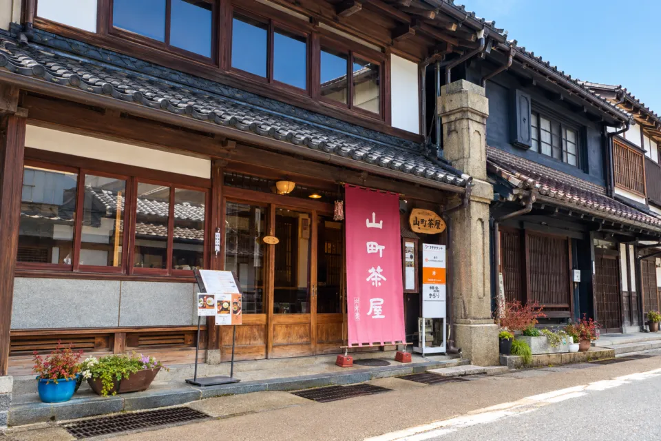 山町茶屋の店舗の赤い暖簾と木造の正面外観