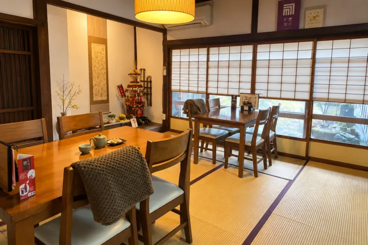 山町茶屋の障子と庭に面した畳敷きのテーブル席
