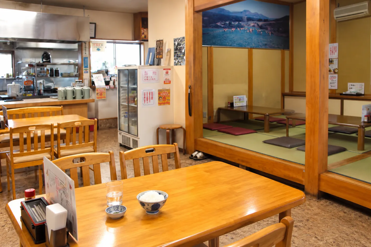 やまな食堂のテーブル席と座敷が見える店内の食卓