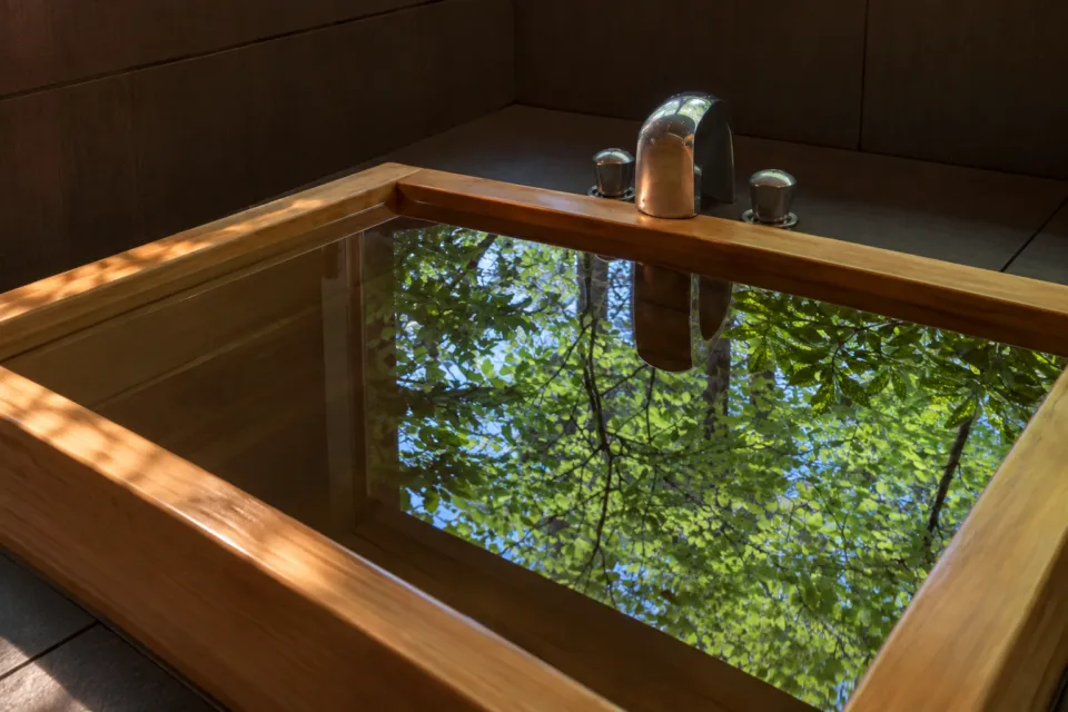 由布院 玉の湯のあかねの檜風呂に映る庭の木々